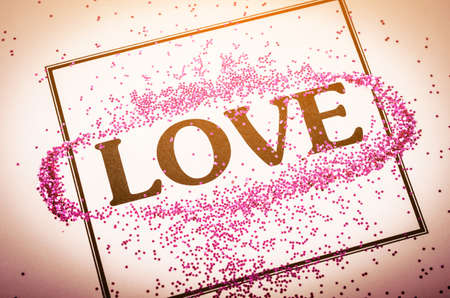 LOVE word with glitter in frame on beautiful paper background, Valentine's day concept.の写真素材