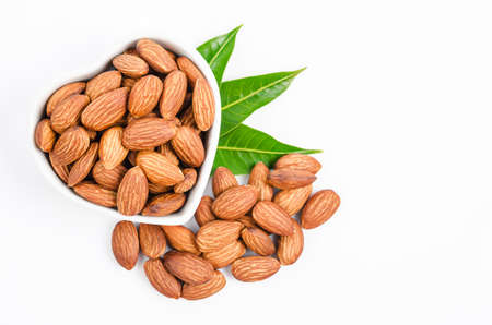 Almonds nuts with green leaf isolated on white background.の写真素材