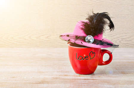 Red coffee cup with hat women on wooden background.の写真素材