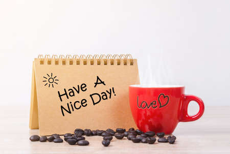 Have a nice day and red hot coffee cup with coffee beans.の写真素材