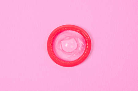 Opened condom on a pink background.の写真素材