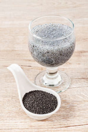 Lemon basil seeds in white spoon and soak in water on wooden background.の写真素材