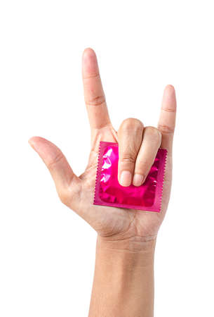 Pink condom in pack on hand showing love symbol isolated on whiteの写真素材