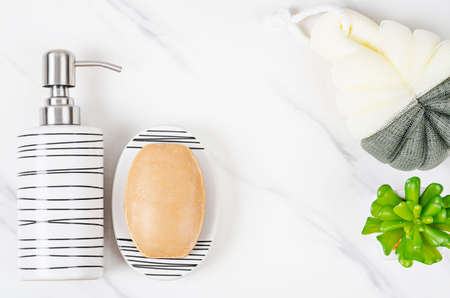 Set of eramic pump bottle for liquid soap or shampoo with herbal soap on marble background.の写真素材