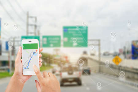 female hands holding a smart phone showing part of navigator map over screen on connection line over...