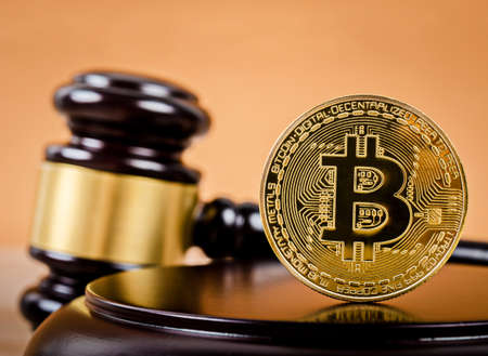golden bitcoin on wooden pedestal of judge gavel on the table.