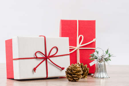 Gift boxs and pine cornes on wooden background.