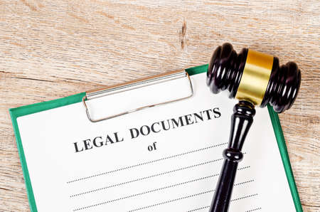 Legal document paper file with gavel on wooden background.の写真素材