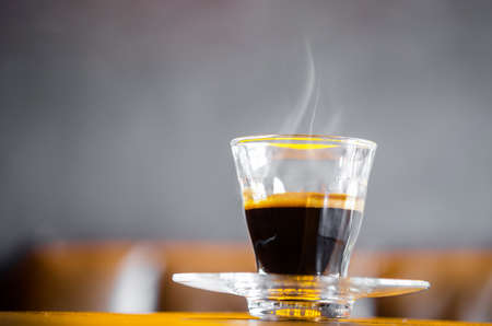 A cup of hot coffee with smoke in coffee shop.の写真素材
