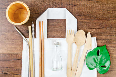 Zero waste concept. Textile eco bags, wooden glass and bamboo utensil on woodenの写真素材
