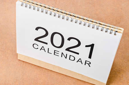 Calendar desk 2021 for organizer to plan and reminder on wooden table.