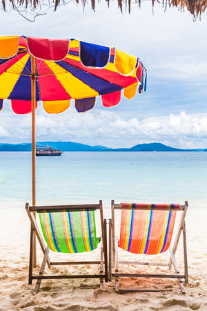 Two colorful beach chair with umbrella on the beach