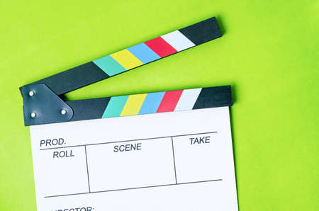 Filmmaker profession. Clapperboard on green background
