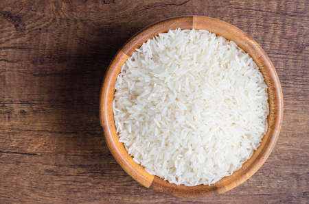 Organic Thai Jasmine rice grain in wooden bowl preparing for cookedの写真素材