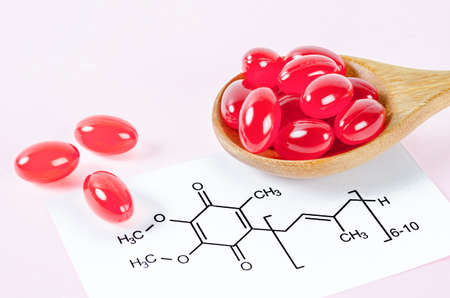 Vitamin Coenzyme Q10 with chemical formula on a pink background. To prevent aging. Pills and medicineの写真素材