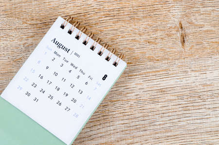 August Calendar 2021 on wooden table background.