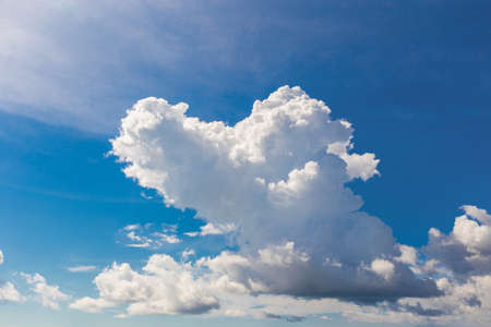 Heart shaped cloud on bright blue sky and white clouds.の写真素材