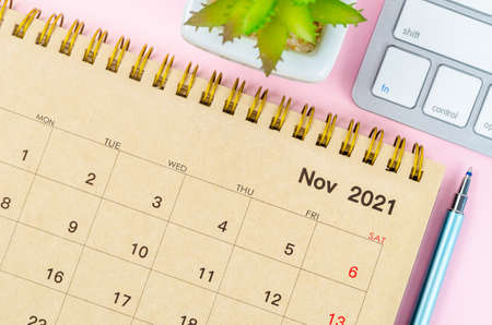 November 2021 desk calendar with keyboard computer on pink background.の写真素材