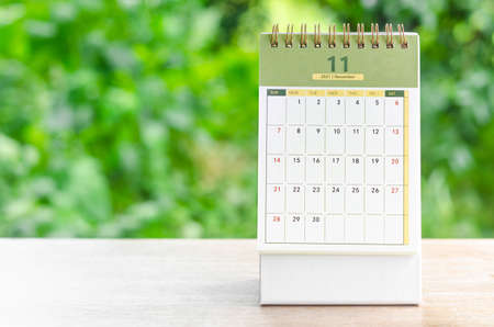 November 2021 Calendar desk for organizer to plan and reminder on wooden table on nature background.の写真素材