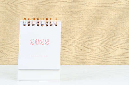 Mini desk calendar 2022 on the white table.