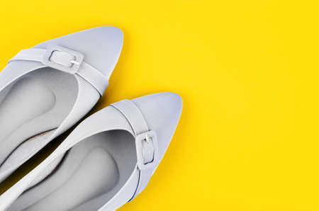 Modern grey color women shoes on yellow background.の写真素材