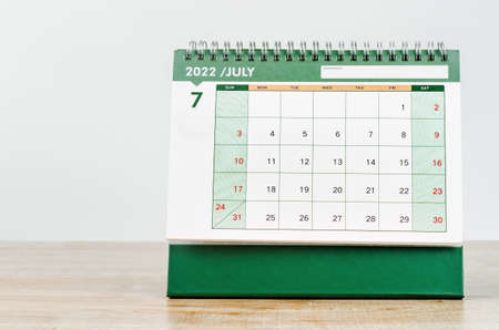 July 2022 desk calendar on wooden table.の写真素材