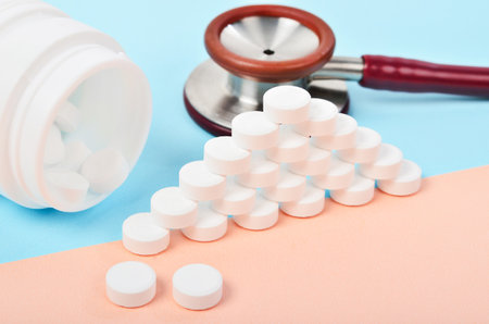 White tablet medicine with medicine stethoscope on blue background.
