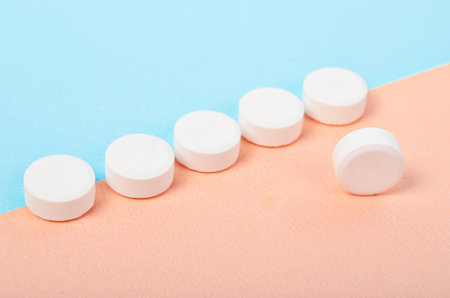 White tablet medicine on blue background.