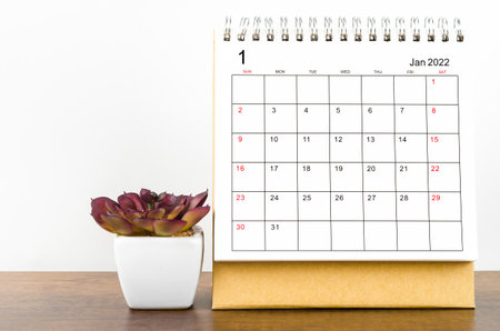 The January 2022 desk calendar with plant pot on wooden table.の写真素材