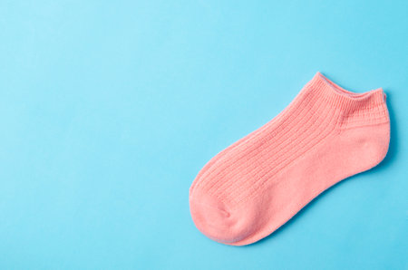 Pink socks on blue background and space for text.の写真素材