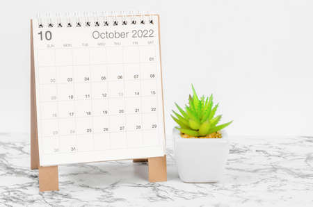 The October 2022 desk calendar with plant on marble table.の写真素材