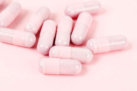 The Pink capsule pills on pink background