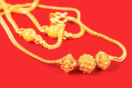Close up the gold necklace on red Velvet fabric.の写真素材