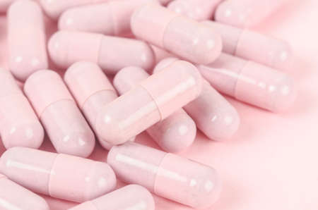 The Pink capsule pills on pink background