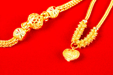 Close up the gold necklace on red Velvet fabric.の写真素材