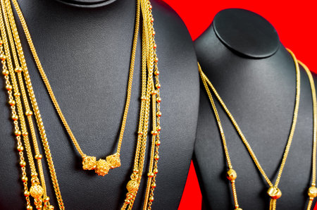 Close up The Necklace display stand with gold necklace on red Velvet fabric.の写真素材