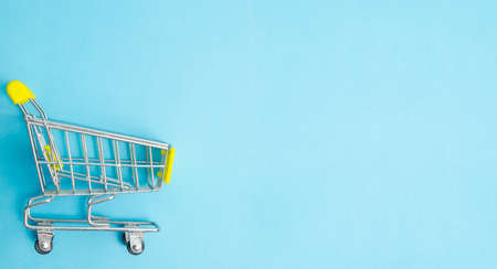 The Yellow Shopping Cart on a isolated blue background. Minimal flat lay with copyspace for your text or message.の写真素材