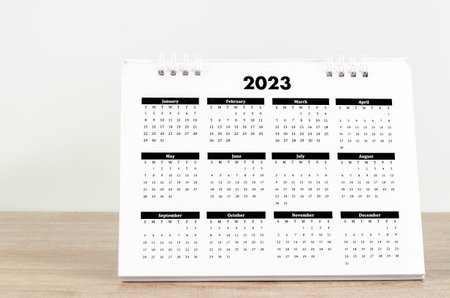 12 months desk calendar 2023 on wooden background.