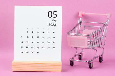 May 2023 Monthly calendar with shopping cart against pink background.の写真素材