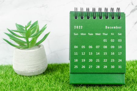 Green December 2022 Monthly desk calendar for 2022 year on grass.