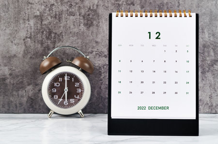 December 2022 Monthly desk calendar for 2022 year and Alarm clock vintage background.の写真素材