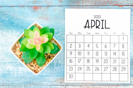 April 2023 Monthly calendar with plant pot on wooden background.の写真素材