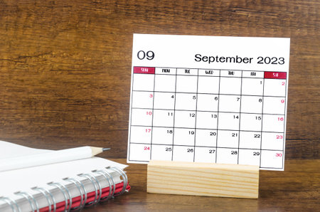 September 2023 Monthly calendar for 2023 year with open diary on wooden background.