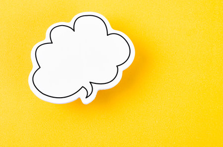 Speech bubble with copy space communication talking speaking concepts on yellow background.の写真素材
