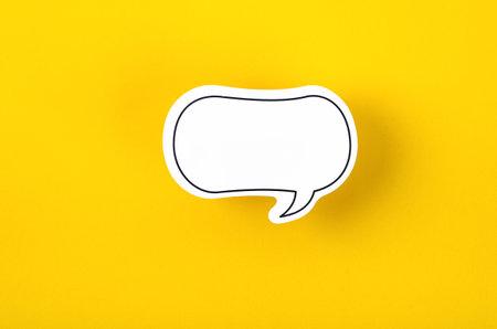 Speech bubble with copy space communication talking speaking concepts on yellow background.の写真素材