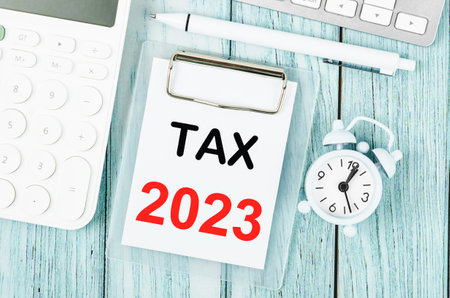 Tax 2023 text on clipboard with pen and calculator on wooden background. 2023 taxation concept.の写真素材
