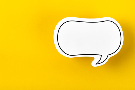Speech bubble with copy space communication talking speaking concepts on yellow background.の写真素材
