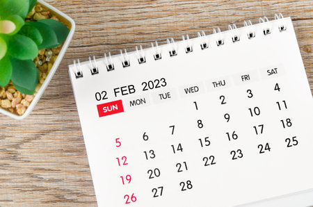 February 2023 desk calendar for 2023 with plant pot on wooden background.の写真素材