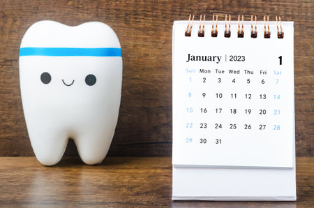January 2023 Monthly desk calendar for 2023 year with Model tooth on wooden table.の写真素材