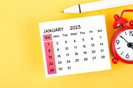 January 2023 Monthly calendar for 2023 year with alarm clock on yellow background.